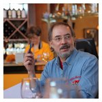 Tom Lesko listens to some discussion over the tops of a few wine glasses