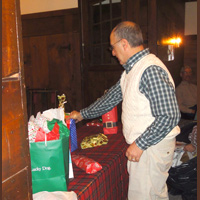 Gene Durso makes a careful choice from the Yankee Swap gift table