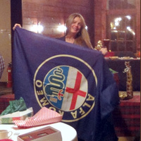 ... which turns out to be a nice Alfa Romeo banner (while a photo of Dave & Vi at LAST year's holiday party plays on Tom's laptop) ...