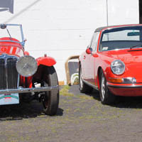At what other car dealership would you find these two cars side by side? A rare as hen's teeth 1934 Jaguar SS 90 is parked next to an equally pristine targa-style Porsche