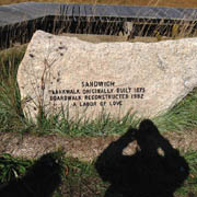 Carved stone marking the rustic boardwalk and wooden bridge in Sandwich