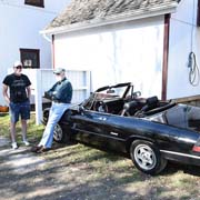 Ken Moshier leans on his Spider chatting with John Rowntree in front of the steam-powered cider mill