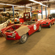 A Giulietta racecar awaits an engine in front of Paul's venerable racer