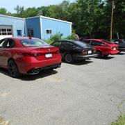 Some six-cylinder Alfa models with the Glynn Motorsports building in the background