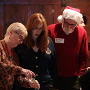 Roberta demonstrates to the awestruck audience how she can fill her wine glass without tipping the bottle