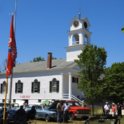 The church on the town green, with classic vehicles in front