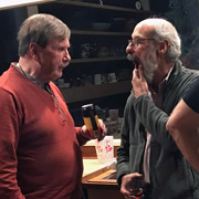 Andy demonstrates to Bruce where the beer he's holding is supposed to go